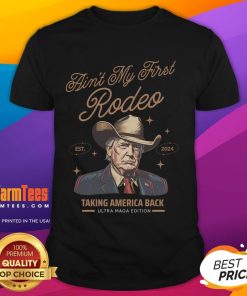 Alt Text: Awesome Ain'T My First Rodeo Trump Cowboy T-Shirt showcasing patriotic design, perfect for Trump supporters.