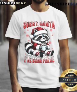Funny raccoon Christmas T-shirt with 'Cute Sorry Santa Ive Been Feral' design, perfect for holiday festivities.