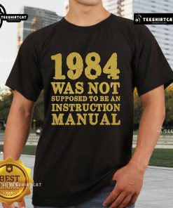 Top 1984 Was Not Supposed To Be An Instruction Manual T-Shirt design featuring bold text and a stylish graphic.
