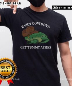 Funny frog wearing a cowboy hat on a T-shirt, showcasing 'Top Even Cowboys Get Tummy Aches' design.