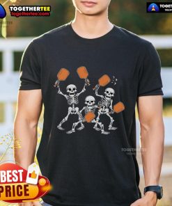 Top spooky skeletons playing pickleball on a Halloween-themed T-shirt design for festive sports lovers.
