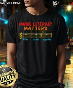Funny Music Literacy Matters T-Shirt featuring a playful 'I Like To Eat Puppies' graphic design.