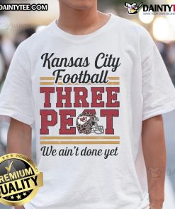 Alt Text: Kansas City Chiefs 'We Ain't Done Yet' helmet leopard t-shirt showcasing team pride and a three-peat celebration.
