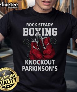 Vintage boxing gloves on a Rock Steadys Boxing Knockout Parkinson T-shirt, promoting awareness and support for Parkinson's.