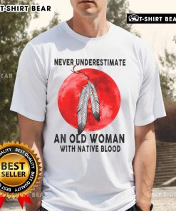 Alt Text: Top Never Underestimate An Old Woman With Native Blood T-Shirt featuring bold graphic design and vibrant colors.