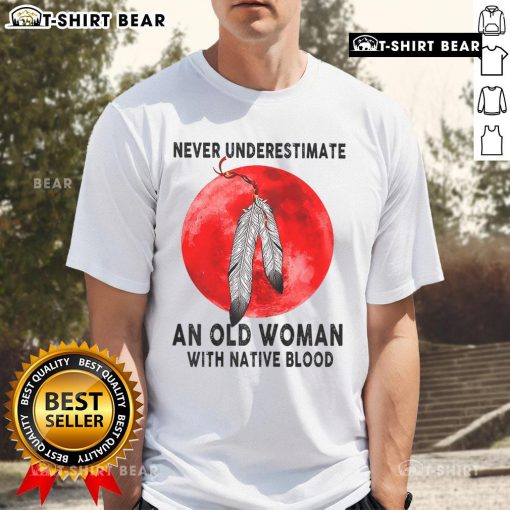 Alt Text: Top Never Underestimate An Old Woman With Native Blood T-Shirt featuring bold graphic design and vibrant colors.