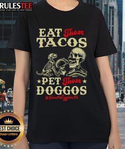Skeleton ladies in taco-themed shirts enjoying tacos and petting dogs, showcasing the Awesome Eat Those Tacos Pet Those Doggos Tee.