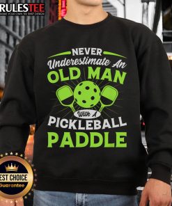 Old man wearing an 'Awesome Never Underestimate An Old Man With A Pickleball Paddle' sweatshirt, ready for pickleball.