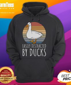 Alt Text: Cute duck wearing a hoodie, easily distracted by other ducks in a vibrant park setting.