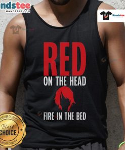 Funny redhead wearing a tank top with a fire graphic on the bed, showcasing a playful and vibrant personality.