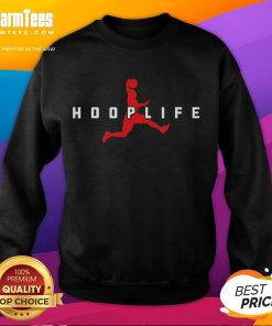 Basketball player wearing a sweatshirt, training with a basketball hoop and ball, showcasing a sporty lifestyle.