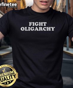 Activist wearing 'Hot Fight Oligarchy Stand Against Corporate Greed' T-shirt at a protest, advocating for social justice.