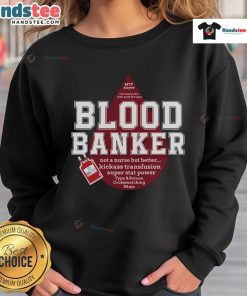 Lab scientist in a Nice Blood Bank sweatshirt at a medical lab during Lab Week, showcasing dedication to science.