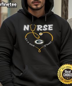 Nice nurse wearing a Green Bay Packers hoodie that says 'It's a Work of Heart,' showcasing team spirit and compassion.