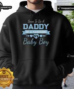 Excited soon-to-be daddy wearing a hoodie announcing arrival of a handsome baby boy, showcasing joyful anticipation.