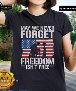 Official 'May We Never Forget - Freedom Isn't Free' Ladies Tee featuring patriotic design and comfortable fit.