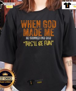 Funny ladies tee featuring the phrase When God Made Me He Grinned and Said This'll Be Fun in vibrant lettering.