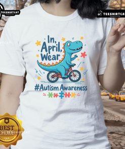 Cute autism awareness dinosaur in April wearing a ladies tee, promoting inclusivity and understanding for autism.