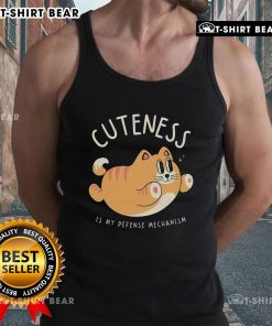 Cute cat wearing a tank top with Cuteness Is My Defense Mechanism text, showcasing adorable feline charm and personality.