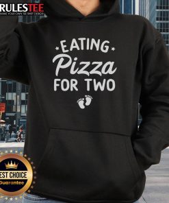 Cute couple in matching hoodies eating pizza, celebrating funny pregnancy announcement with joy and laughter.