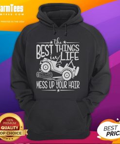 Person wearing a hoodie on a truck hood, laughing with messy hair, capturing the funny best things in life this summer.