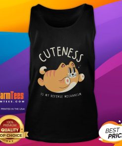 Alt Text: Funny cat wearing a cute tank top with 'Cuteness Is My Defense Mechanism' text, showcasing playful feline charm.