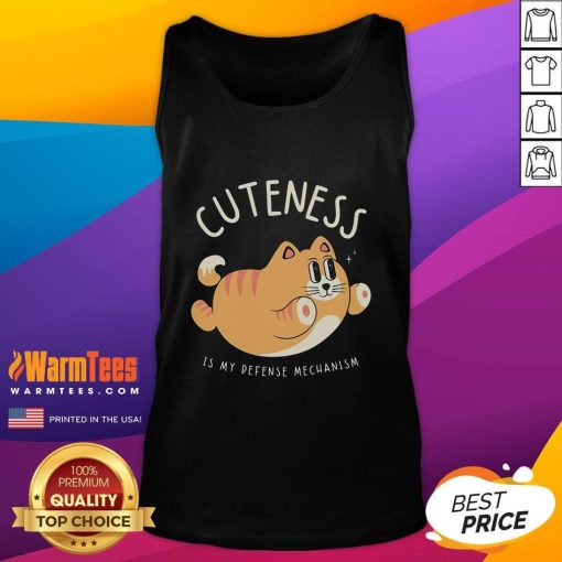 Alt Text: Funny cat wearing a cute tank top with 'Cuteness Is My Defense Mechanism' text, showcasing playful feline charm.