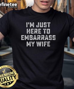 Alt Text: Funny I'M Just Here To Embarrass My Wife Husband T-Shirt design featuring humorous text for couples.