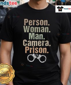 Funny person wearing a prison-themed T-shirt poses with a man and a camera, showcasing unique style and humor.