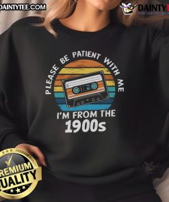 Alt Text: Vintage 'Please Be Patient With Me I'm From The 1900s' VHS tape sweatshirt against a sunset backdrop, showcasing retro style.