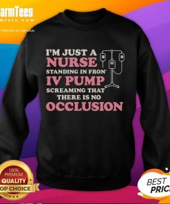 Alt Text: Nurse wearing 'Good I'm Just A Nurse' sweatshirt standing in front of an IV pump in a hospital setting.