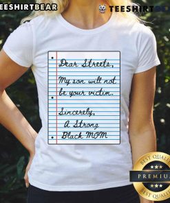 Strong Black mom wearing 'My Son Will Not Be Your Victim' tee on a street, promoting empowerment and protection.