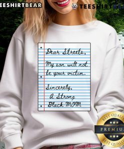 Strong Black mom wearing 'My Son Will Not Be Your Victim' sweatshirt, walking on a nice street with confidence.