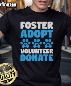 Volunteer in a 'Foster Adopt Donate' T-shirt supporting animal rescue for dogs and cats at a shelter.