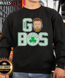Kristaps Porzingis wearing a Boston Celtics sweatshirt, showcasing team spirit and style during a game.