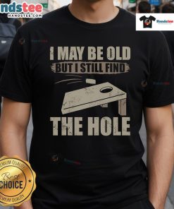 Funny cornhole t-shirt saying 'I May Be Old But I Still Find The Hole' perfect for cornhole enthusiasts.