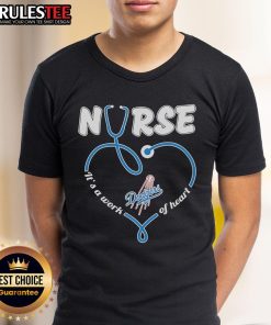 Alt Text: Los Angeles Dodgers Nurse 'It's A Work Of Heart' T-Shirt featuring team logo and heart design for baseball fans.