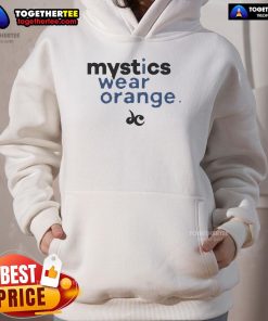 Nice Mystics wearing an orange hoodie, showcasing vibrant street style and cozy fashion in a casual outdoor setting.