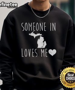 Cozy 'Someone in Michigan State Loves Me' sweatshirt displayed against a rustic backdrop, perfect for fans and gifts.