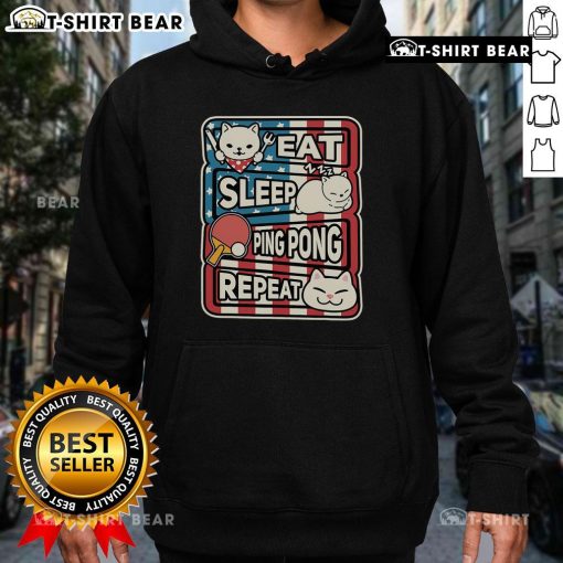 Cute cat in a patriotic hoodie, showcasing a 'Eat Sleep Ping Pong Repeat' design, perfect for table tennis lovers.