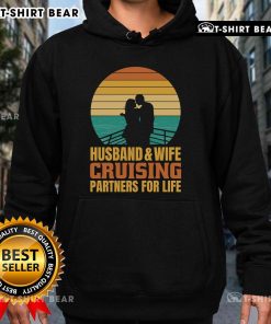 Couple wearing 'Top Husband and Wife Cruising Partners for Life' hoodie against a vintage sunset backdrop on a cruise.