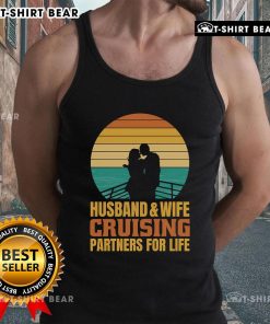Couple wearing 'Top Husband and Wife Cruising Partners for Life' vintage tank tops against a beautiful sunset backdrop.
