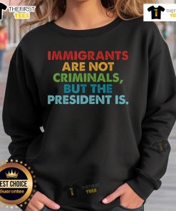 Top-Immigrants-Are-Not-Criminals-But-The-President-Is sweatshirt promoting immigrant rights and social justice.
