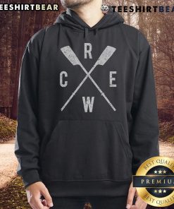 Top rowing crew in crossed oars formation, showcasing rowers and coach in scull hoodies during practice.