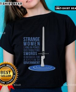 Strange women in ponds distributing swords, showcasing the 'Ladies Tee' design, humorously critiquing government systems.