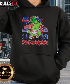 Alt Text: Awesome Phillie Phanatic mascot in 1883 Philadelphia Phillies skyline hoodie, showcasing team spirit and vibrant colors.