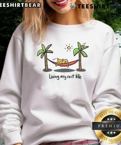 Alt Text: Cute cat lounging in a cozy sweatshirt, embodying the 'Living My Rest Life' vibe for ultimate comfort.