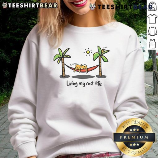 Alt Text: Cute cat lounging in a cozy sweatshirt, embodying the 'Living My Rest Life' vibe for ultimate comfort.