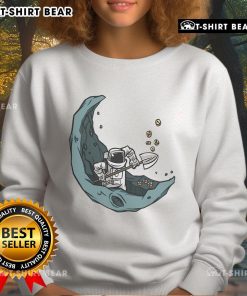 Funny astronaut mining on the moon for space coins on a cozy sweatshirt, perfect for space enthusiasts.