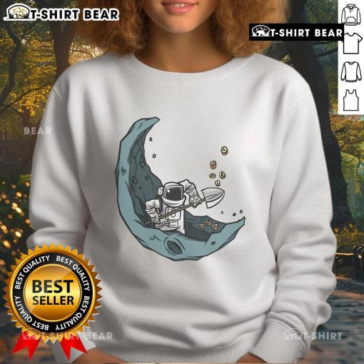 Funny astronaut mining on the moon for space coins on a cozy sweatshirt, perfect for space enthusiasts.